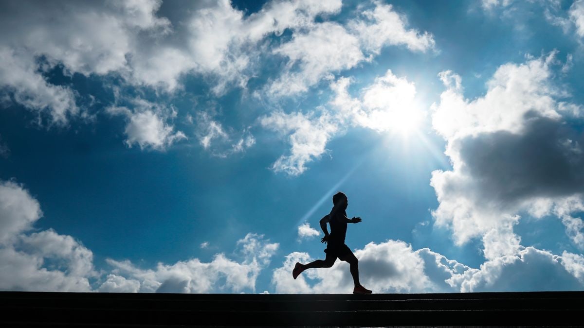 Dynamic silhouette of a person running with a bright sky in São Paulo, capturing motion and tranquility.